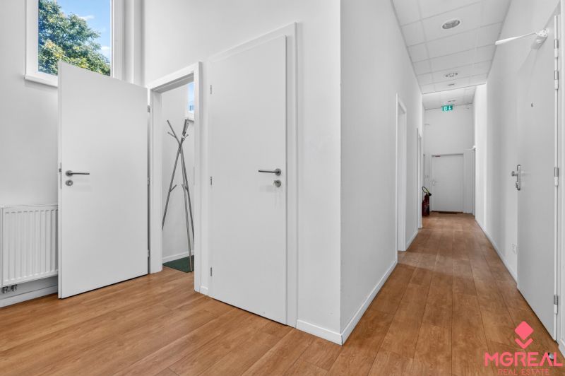 Interior of commercial spaces with white walls, wood-patterned flooring, and a wardrobe.