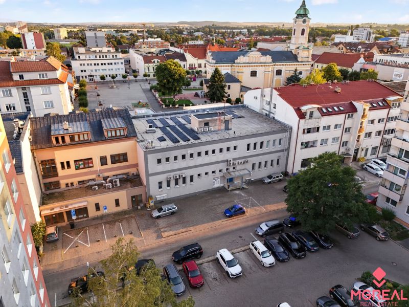 View of M.R. Štefánik in Topoľčany with commercial spaces and a church in the background.
