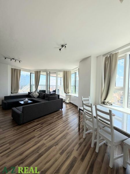 Bright living room with a sofa and wood-patterned flooring, 3-room apartment.