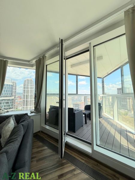 Living room with a sofa and access to a balcony in a 3-room apartment with a view.