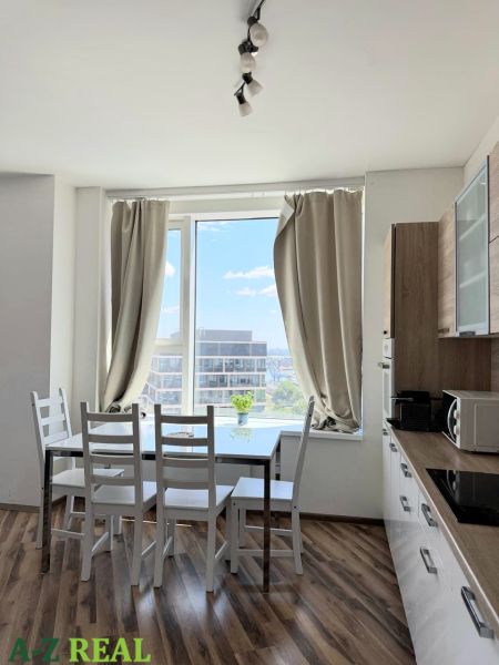 A kitchen with a dining table, a floor with wooden decor, in a 3-room apartment.