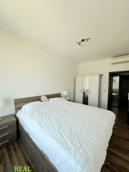 A bedroom with a double bed, a wardrobe, and a wooden decor floor in a 3-room apartment.
