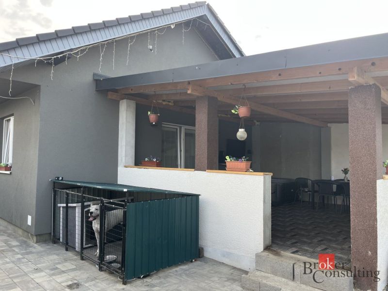 A family house in Čaňa on SNP Street with a terrace, paving, and a fenced run for a dog.