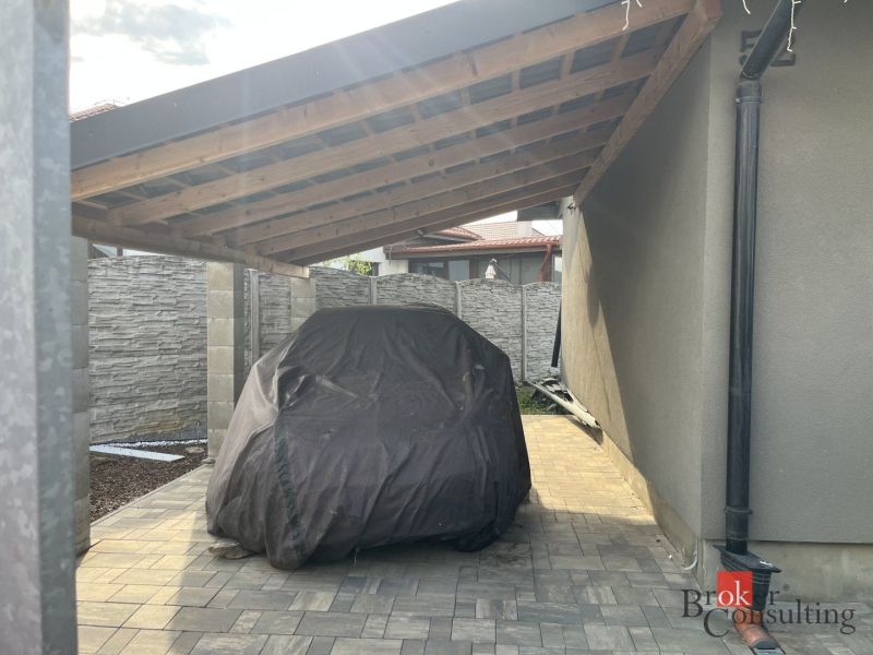 A family house on SNP Street in Čaňa with a shelter and a covered car.
