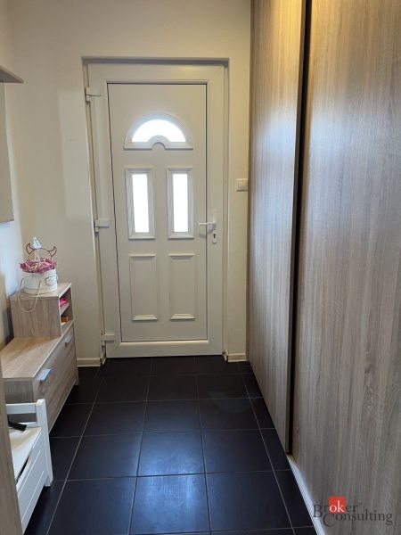 Entrance hall in a family house with white doors and furniture with a wooden decor.