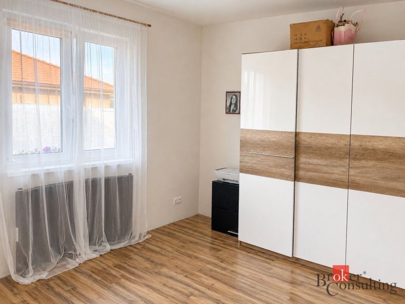 A white wardrobe with a wood decor and curtains in the room of a family house.