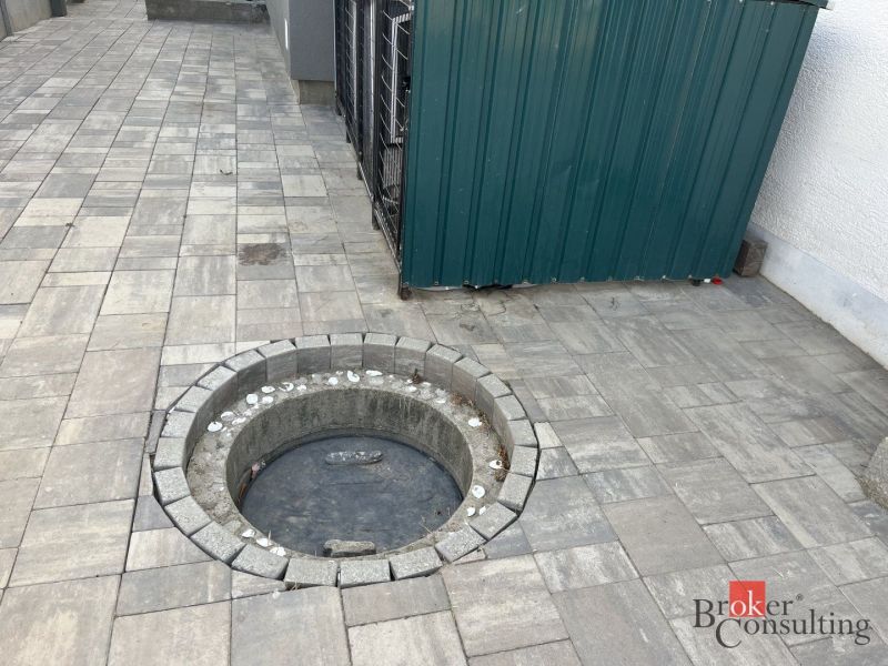 Along the concrete pavement of the family house on SNP in Čaňa, there is a circular manhole cover.