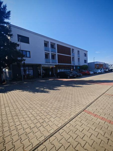 The building on Senická Street in Rohožník with parking spaces in the foreground.
