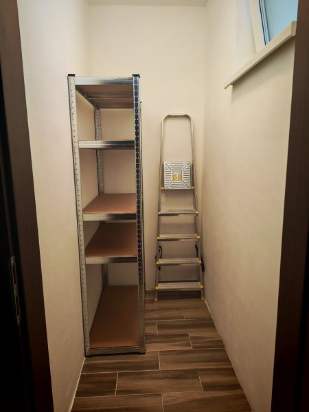 Storage space in a 2-room apartment with a shelving system and a ladder.