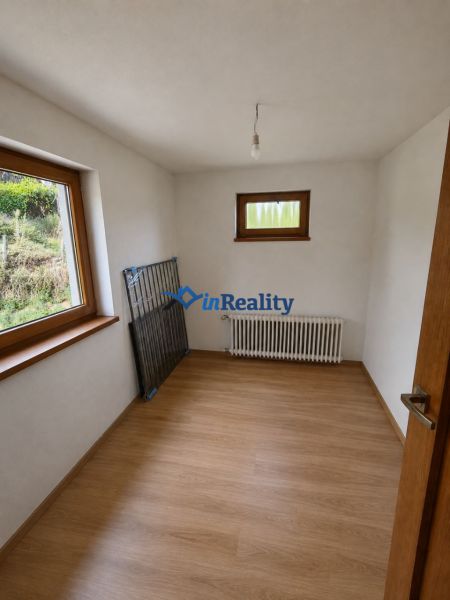 A room in a family house with a radiator and a wooden decor floor.