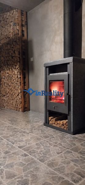 A family house with a wood-burning stove and a stone-patterned floor.