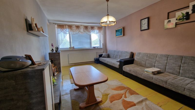 Living room with sofas, a coffee table, and a wooden decor floor in a family house.