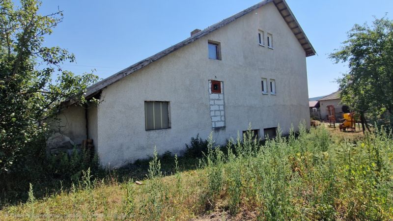 A family house on Biela Street in Kazimír surrounded by greenery under a blue sky.
