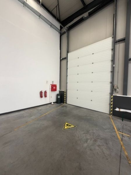 In the interior of warehouses and halls, a white wall and safety features are visible.