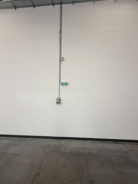 White wall with a socket in the interior of warehouses and halls.