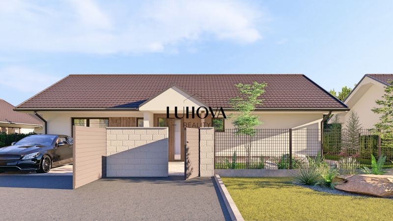 A family house in Tuchyňa on Tuchyňa Street with a car at the entrance and cladding.