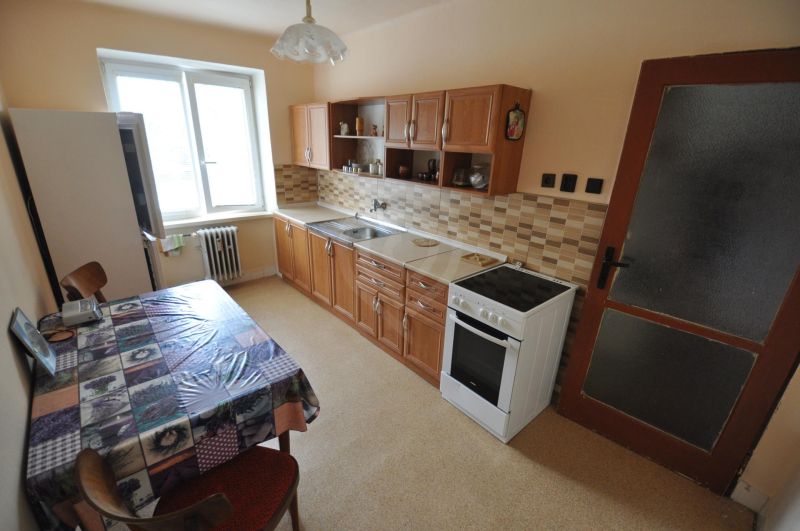 Kitchen in a 2-room apartment with a dining table, kitchen unit, and appliances.