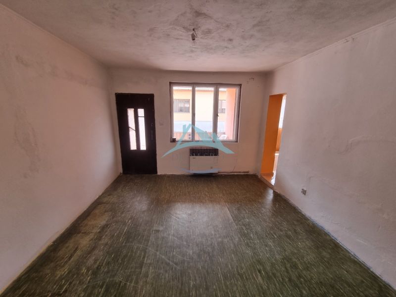 An empty room with a wooden floor in a family house.