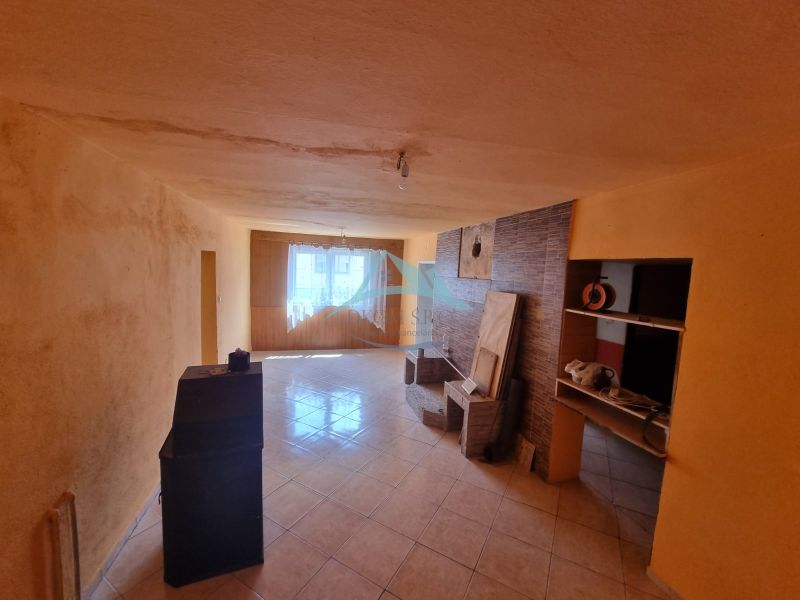 Living room in a family house with a tiled floor and a skylight.