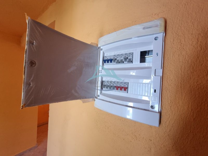 An electrical distribution box with open doors in the interior of a family house.
