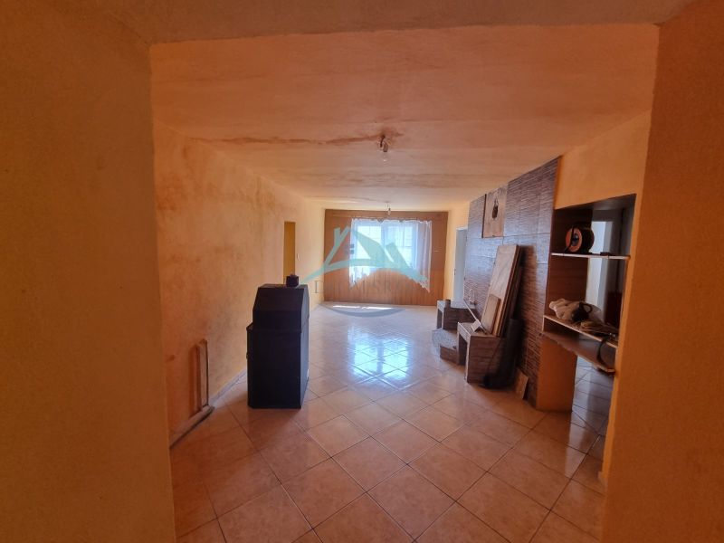The interior of a family house with a ceramic floor and beige walls, illuminated by the spaces.