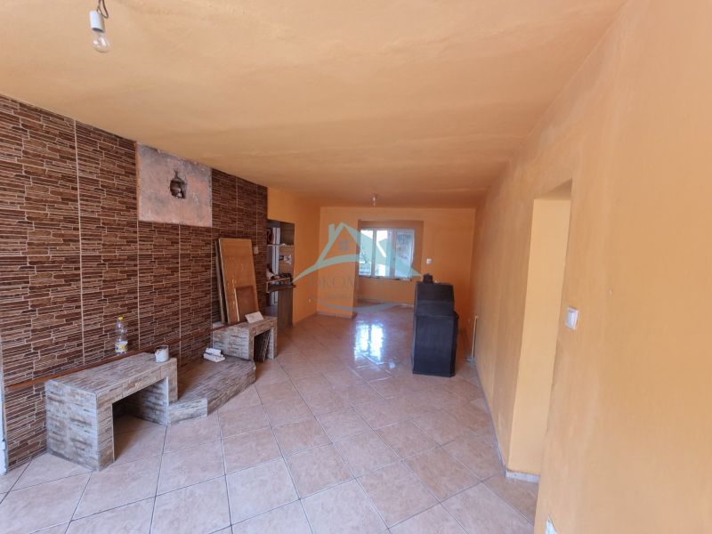 A room with tiled flooring, orange walls, and brick cladding in a family house.