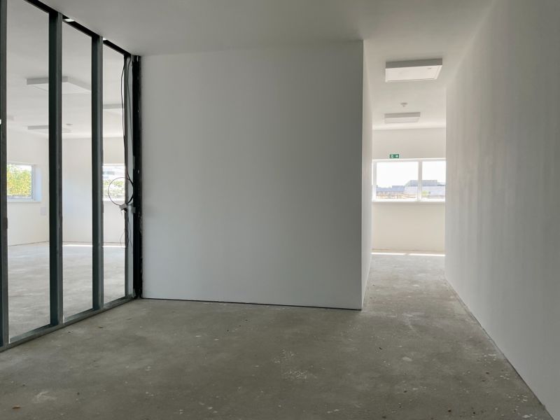 Interiors of warehouses and halls with transparent glass partitions and concrete floors.