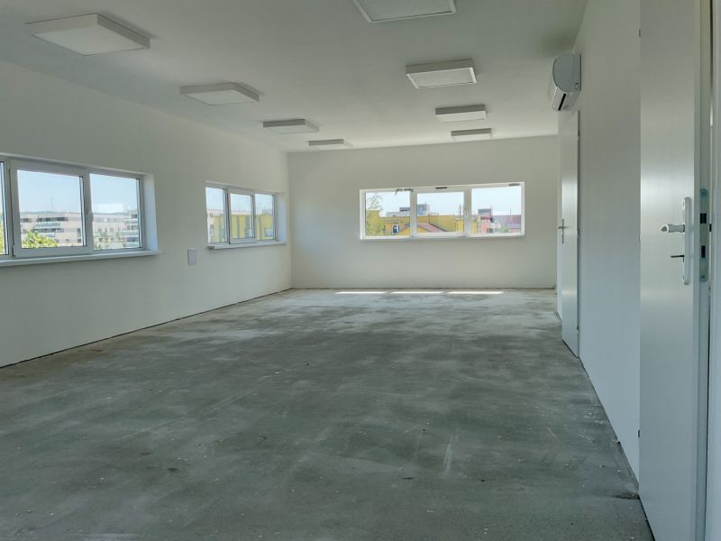 Interiors in warehouses and halls with windows and gray floors.