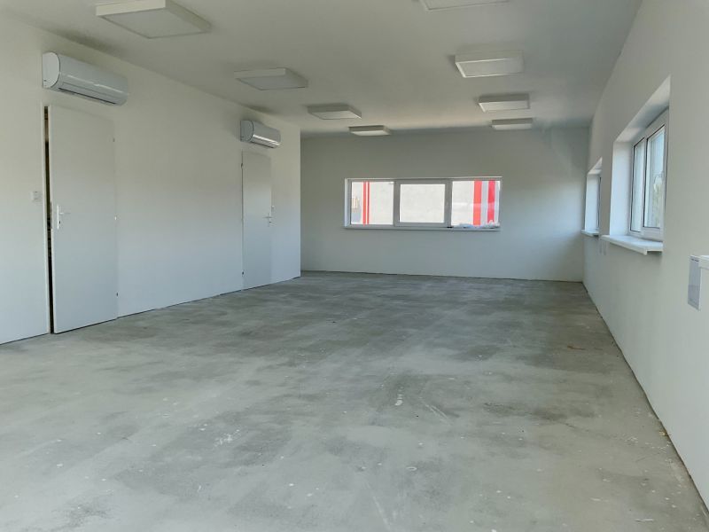 Interior with air conditioning units and large windows suitable for warehouses and halls.