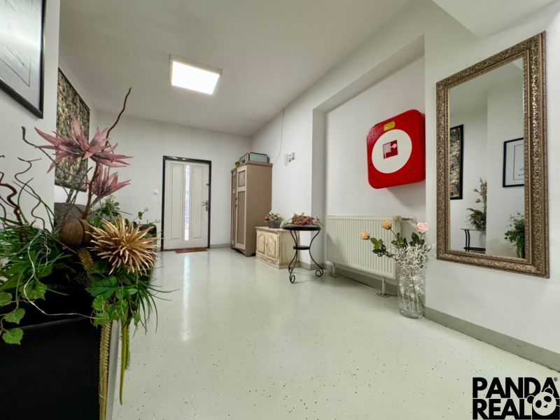 Commercial premises with floral decoration, large mirror, and security equipment.