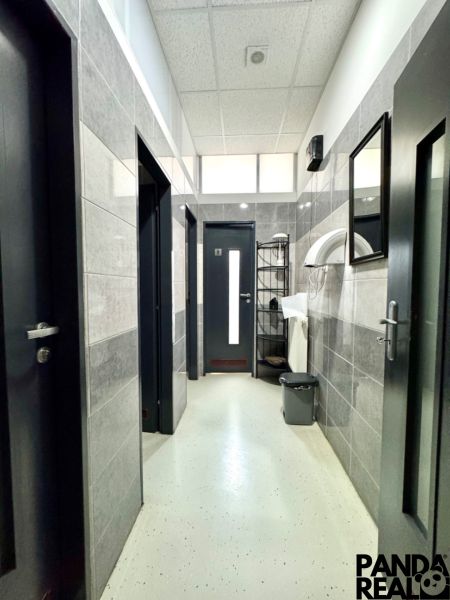 Interior of commercial spaces with white walls and plastic flooring in neutral tones.