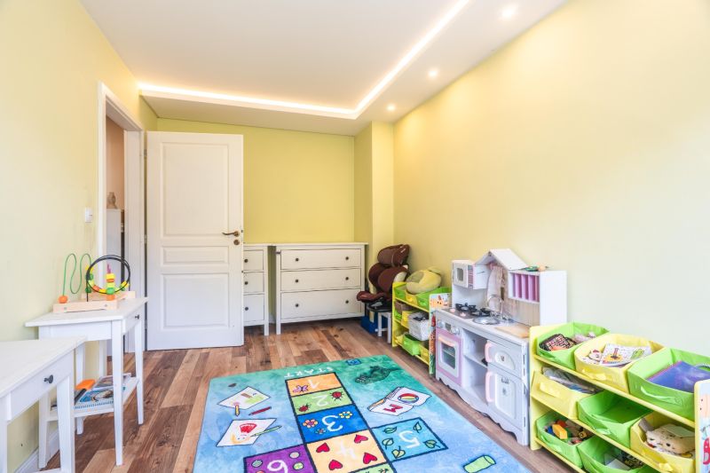 Children's room in a 4-room apartment with a colorful carpet and a wooden decor floor.