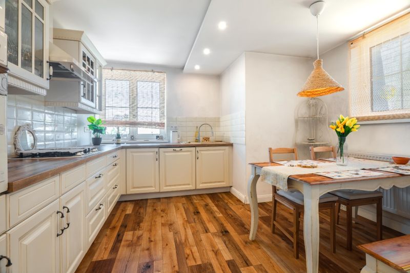 A kitchen in a 4-room apartment with a wooden decor floor and a dining area.