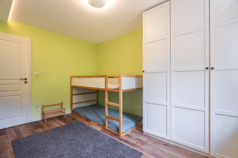 Children's room in a 4-room apartment with a bunk bed and a wardrobe, floor with wooden decor.