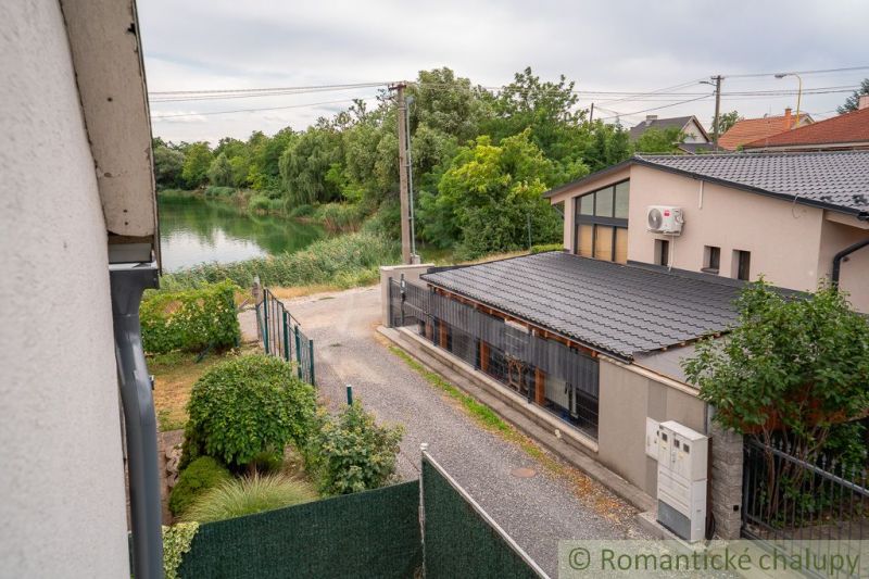 A lake and a cottage in Senec with picturesque nature and greenery around.