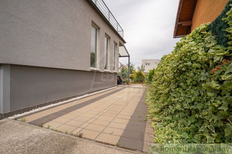 The side yard of the cottage in Senec with a garden and terrace.