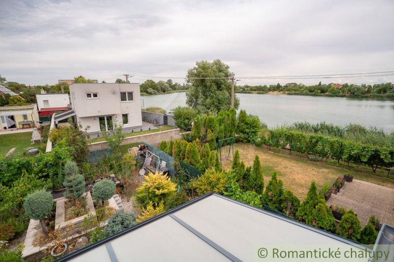 View from the cottage by the lake in Senec, surrounded by a lush garden.