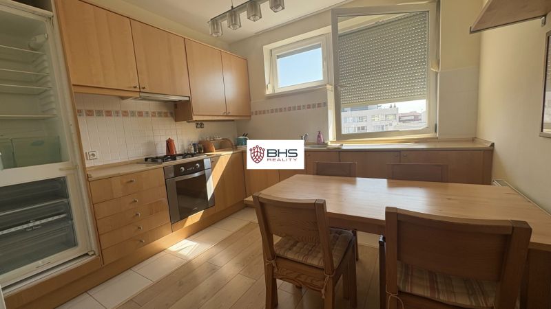 A kitchen in a 2-room apartment with a wooden decor and built-in appliances.