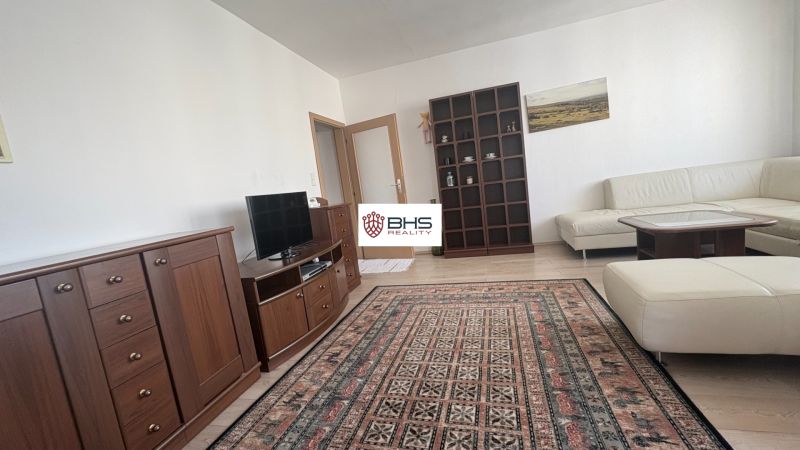Living room in a two-room apartment with a wooden decor floor and comfortable furniture.
