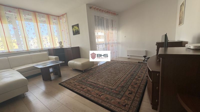 Living room with a sofa set, table, and wooden decor flooring.
