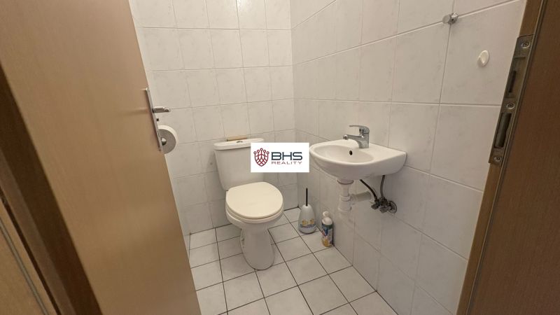 A toilet with basic equipment in a 2-room apartment, white ceramic tiles.