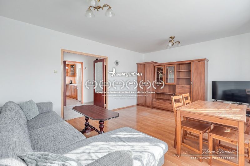Living room in a three-room apartment with a wooden decor floor and furniture.