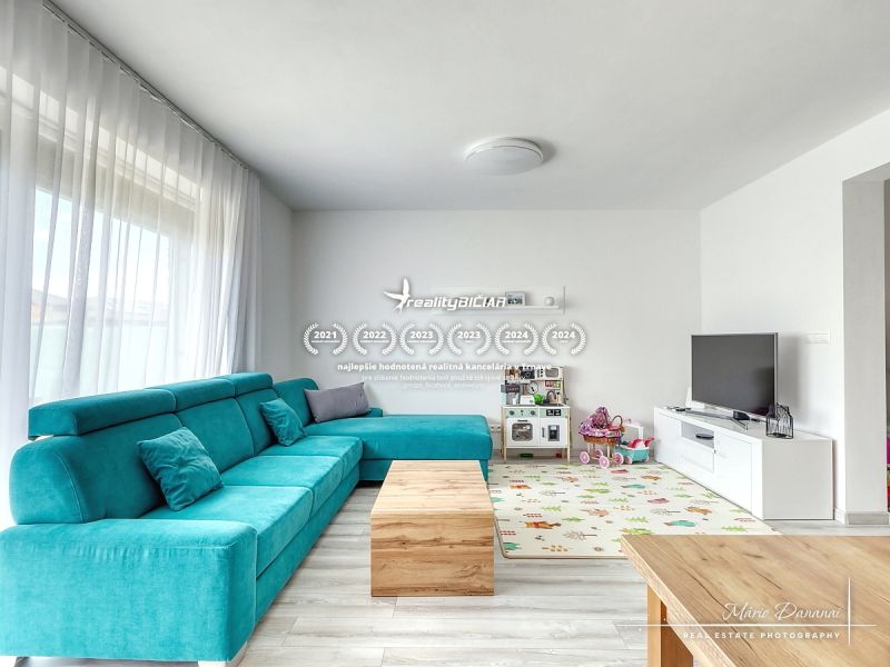 Living room in a family house with a turquoise sofa, television, and children's toys on Lipova Street.
