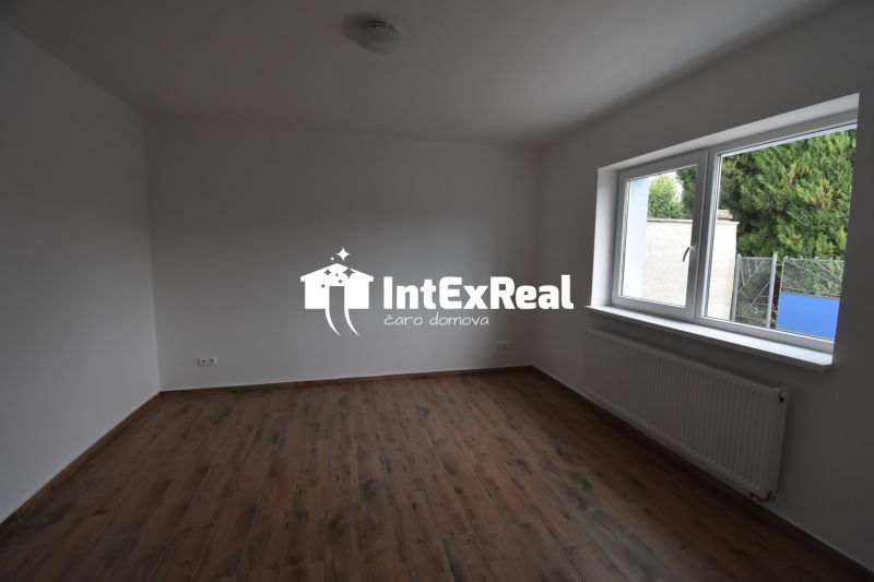 The interior of commercial spaces with white walls and a wooden decor floor.