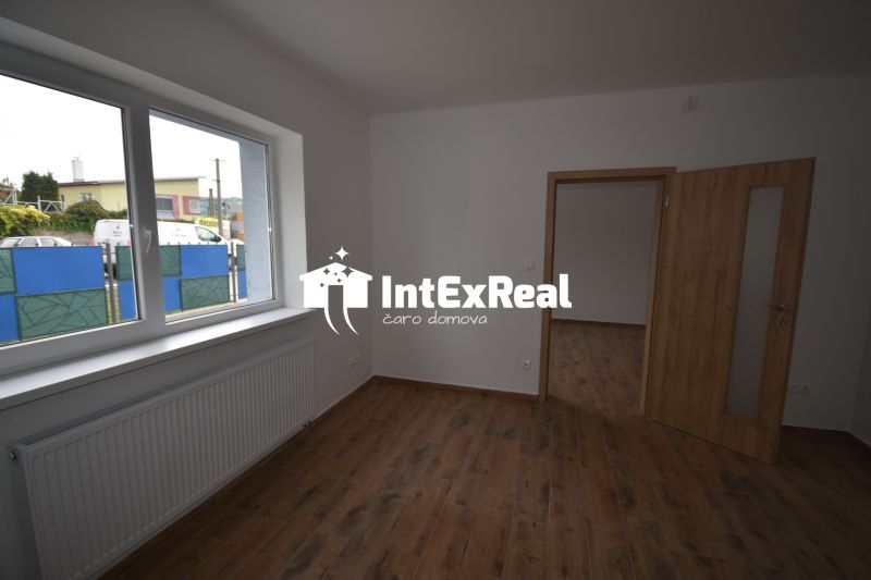 Interior of commercial spaces with wood-patterned flooring and a large window.