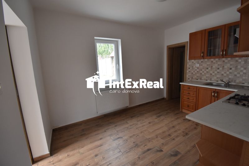 A kitchen space with a wooden decor floor and a wooden kitchen unit.