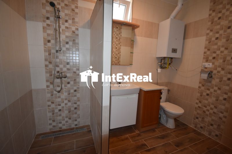 Bathroom in commercial premises with tile and wooden decor flooring.