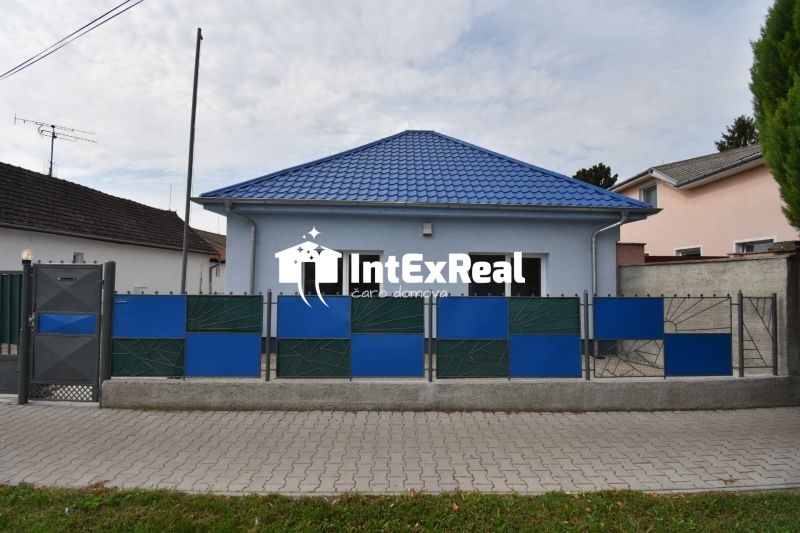 The exterior of commercial premises on Dlhoveská Street in Šaľa with a blue roof and fence.
