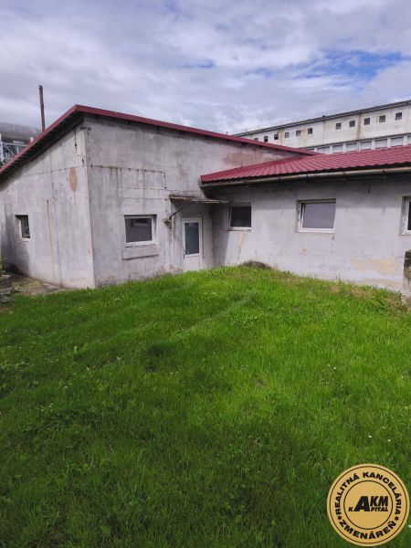 Warehouses and halls in Žiar nad Hronom with green lawns and gray facades.