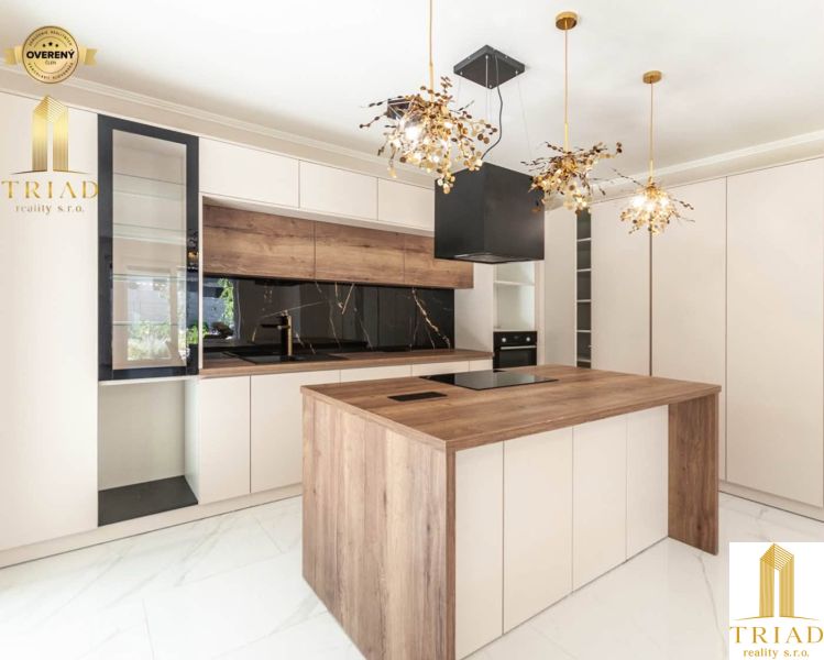 A kitchen with an island and a wooden decor floor in a family house.